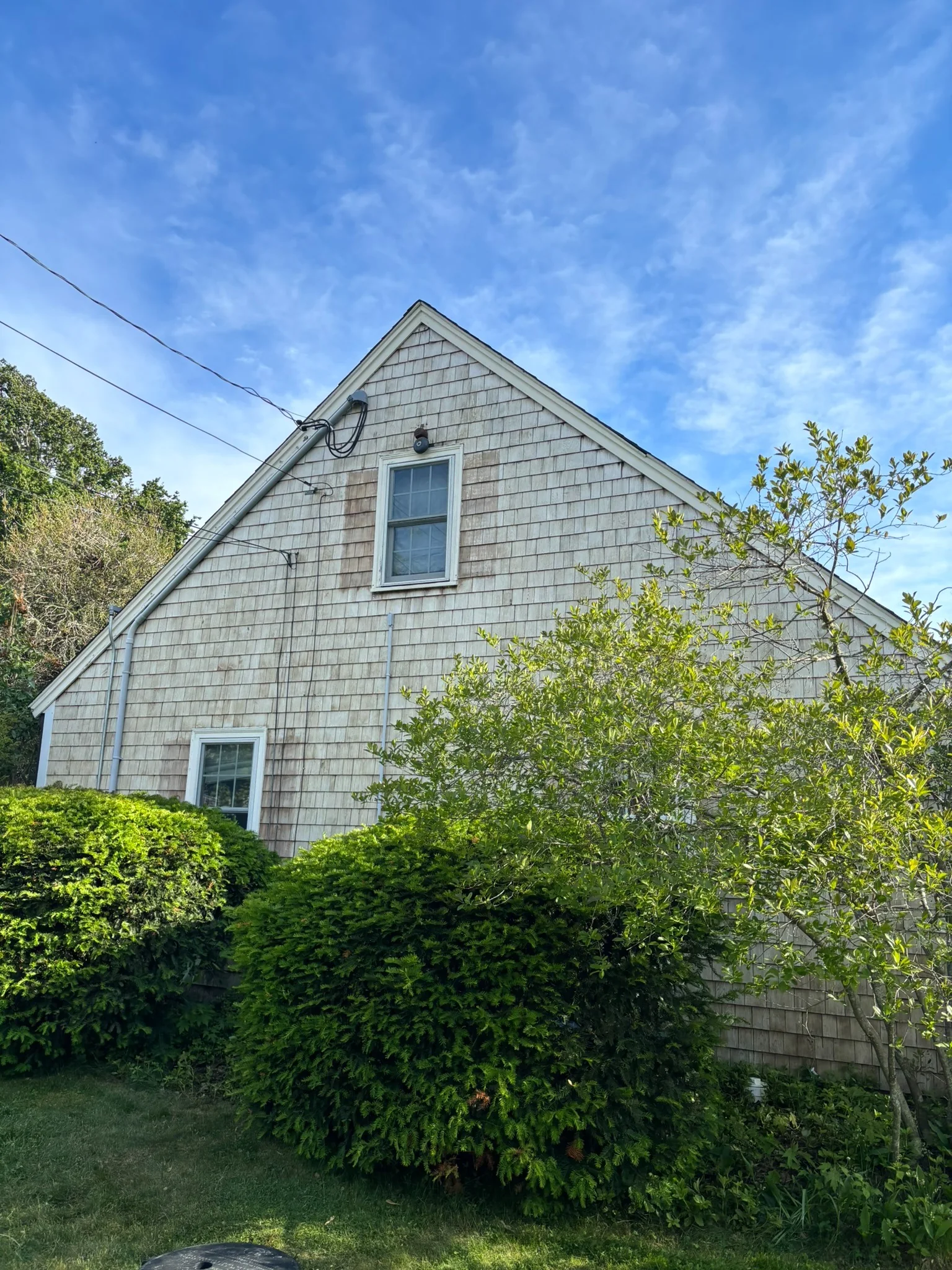 The same cedar-shingle gable after cleaning